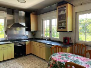 a kitchen with wooden cabinets and a table in it at Finca la Tierruca de Cudon in Cudón