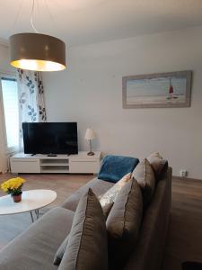 a living room with a couch and a flat screen tv at Walhalla Kuhala apartment in Forssa +9 photos