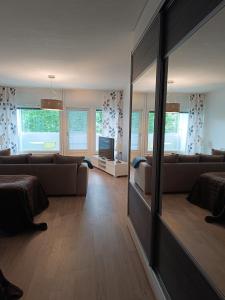 a living room with a couch and a large mirror at Walhalla Kuhala apartment in Forssa