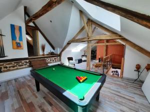 a room with a pool table in a attic at Maison d'hôtes en grès rouge in Lanteuil