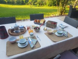 a table with a white table cloth with food on it at Maison d'hôtes en grès rouge in Lanteuil
