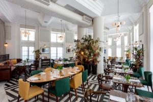 ein Esszimmer mit Tischen, Stühlen und Fenstern in der Unterkunft Fera Palace Hotel in Salvador