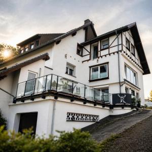ein weißes Haus mit Balkon in der Unterkunft Wellness Appartement Eifelglück in Pelm