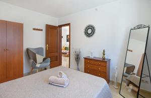 a bedroom with a bed and a mirror and a chair at Apartamentos Bellavista in Puerto del Carmen