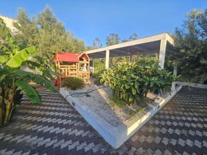 a garden with a pavilion with trees and plants at Affittacamere Vacanze a Posada in San Giovanni