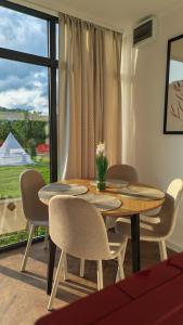a dining room with a table and chairs and a window at Pura Vida Mountain Glamping-tiny houses and tents in Moieciu de Jos +112 photos
