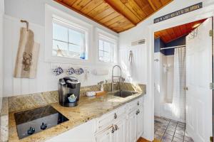 a kitchen with white cabinets and a sink at The Atlantic in Yarmouth