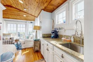 a kitchen with a sink and a living room at The Atlantic in Yarmouth
