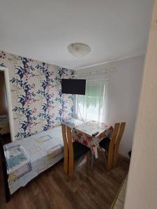 a room with a table and chairs and a table and a bed at Deskom Zelena Vila in Veliko Gradište