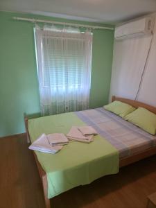 a bedroom with a bed with towels on it at Deskom Zelena Vila in Veliko Gradište