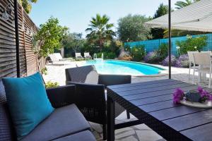 a patio with a table and chairs and a pool at Ferienhaus Rafalenadjan, ideal für Familien, eigener Pool, schöne Terrasse, eigener Parkplatz by Riviera Homelife Management in Saint-Raphaël