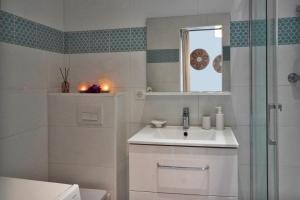 a white bathroom with a sink and a shower at Ferienhaus Rafalenadjan, ideal für Familien, eigener Pool, schöne Terrasse, eigener Parkplatz by Riviera Homelife Management in Saint-Raphaël +7 photos