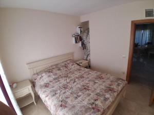 a bedroom with a bed with a floral bedspread at Marina Bay in Kranevo