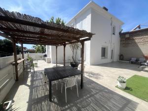a patio with a table and chairs under a pergola at La Maison Blanche in Perpignan