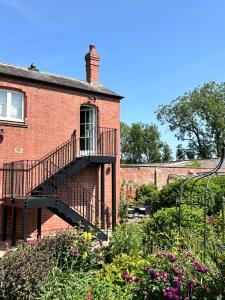 a brick building with a staircase on the side of it at Cockloft Romantic Countryside Hideaway in Bishops Cannings