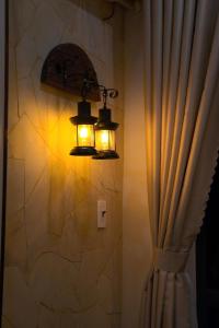 a bathroom with two lights on the wall and a curtain at Thong dong homestay&villas in Quỳnh Lưu