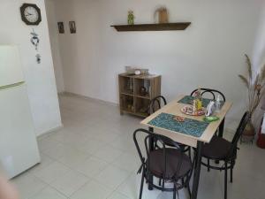 a kitchen with a table and chairs and a refrigerator at Hibiscus Green Apartments in Afantou