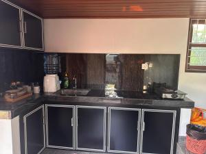 a kitchen with black cabinets and a counter top at Breeze Heven Cabana in Matale