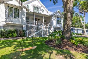 a house with a swing in front of a tree at 26th Ave 23 in Isle of Palms