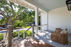 a porch with wicker chairs and a tree at 26th Ave 23 in Isle of Palms