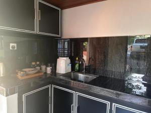 a kitchen with black cabinets and a sink at Breeze Heven Cabana in Matale