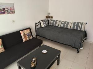 a living room with a couch and a table at Hibiscus Green Apartments in Afantou