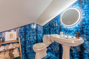 a blue tiled bathroom with a sink and a toilet at Maison Blanche in Bordighera +22 photos