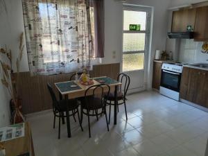 a small kitchen with a table and chairs in it at Hibiscus Green Apartments in Afantou +12 photos