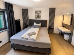 a bedroom with a large bed with a sink and a bed sidx sidx at Haus am Stein in Stuhlfelden