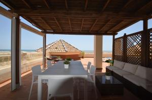 a patio with a white table and a couch at Playa Grande SOLMARES in Isla del Moral