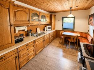 a kitchen with wooden cabinets and a dining table at Haus am Stein in Stuhlfelden