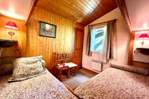 a bedroom with two beds and a window at Les Toits des Cateaux in Combloux +6 photos