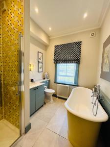 a bathroom with a tub and a sink and a toilet at Cockloft Romantic Countryside Hideaway in Bishops Cannings +19 photos