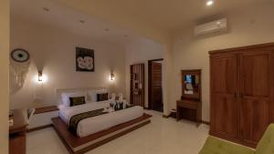 a large bedroom with a bed and a wooden cabinet at Mango Garden in Gili Islands +56 photos