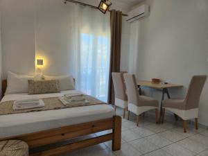 a bedroom with a bed and a table and chairs at Galini Apartments in Bali