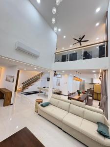 a living room with a couch and a dining room at Chin Villa in Simpang Ampat