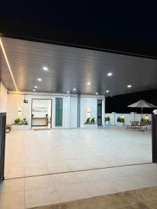 a large empty room with a large white room with an open ceiling at Chin Villa in Simpang Ampat