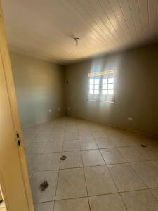 an empty room with a window and a tile floor at Apto a 50m da ExpoCrato in Crato