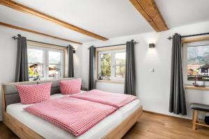 a bedroom with a bed with red and white pillows at Landhaus Speiser in Bolsterlang