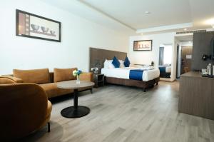 a hotel room with a bed and a couch at Alisa Hotel North Ridge in Accra