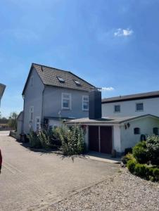 a blue house with a garage in a driveway at Ferienwohnung Lykos in Süderbrarup