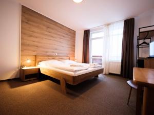 a bedroom with a large bed with a wooden wall at Vyhliadka Galfy in Starý Smokovec