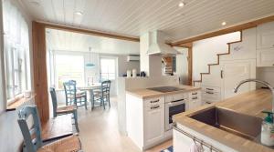 a kitchen with a sink and a table with chairs at Cabin by Gáansá in Sandavágur