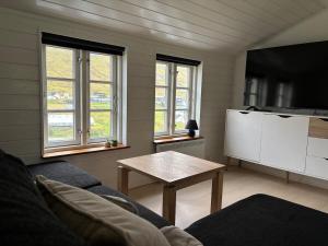 a living room with a couch and a table at Cabin by Gáansá in Sandavágur