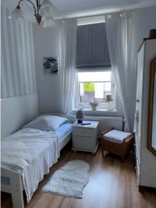 a small bedroom with a bed and a window at Ferienwohnung Lykos in Süderbrarup
