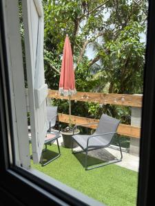 a patio with a chair and an umbrella at Bas de villa Kay Lanati in Le François