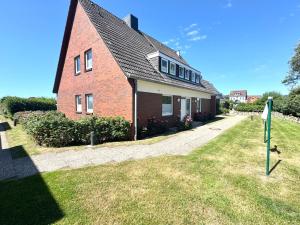 a red brick house with a sign in front of it at Risgap 1 A, App 7 in Wenningstedt