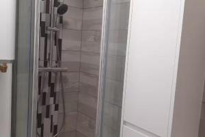 a shower with a glass door in a bathroom at Autan-tic in Castres
