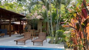 a group of chairs sitting next to a pool at Mango Garden in Gili Islands