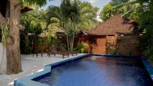 a swimming pool in front of a house at Mango Garden in Gili Islands